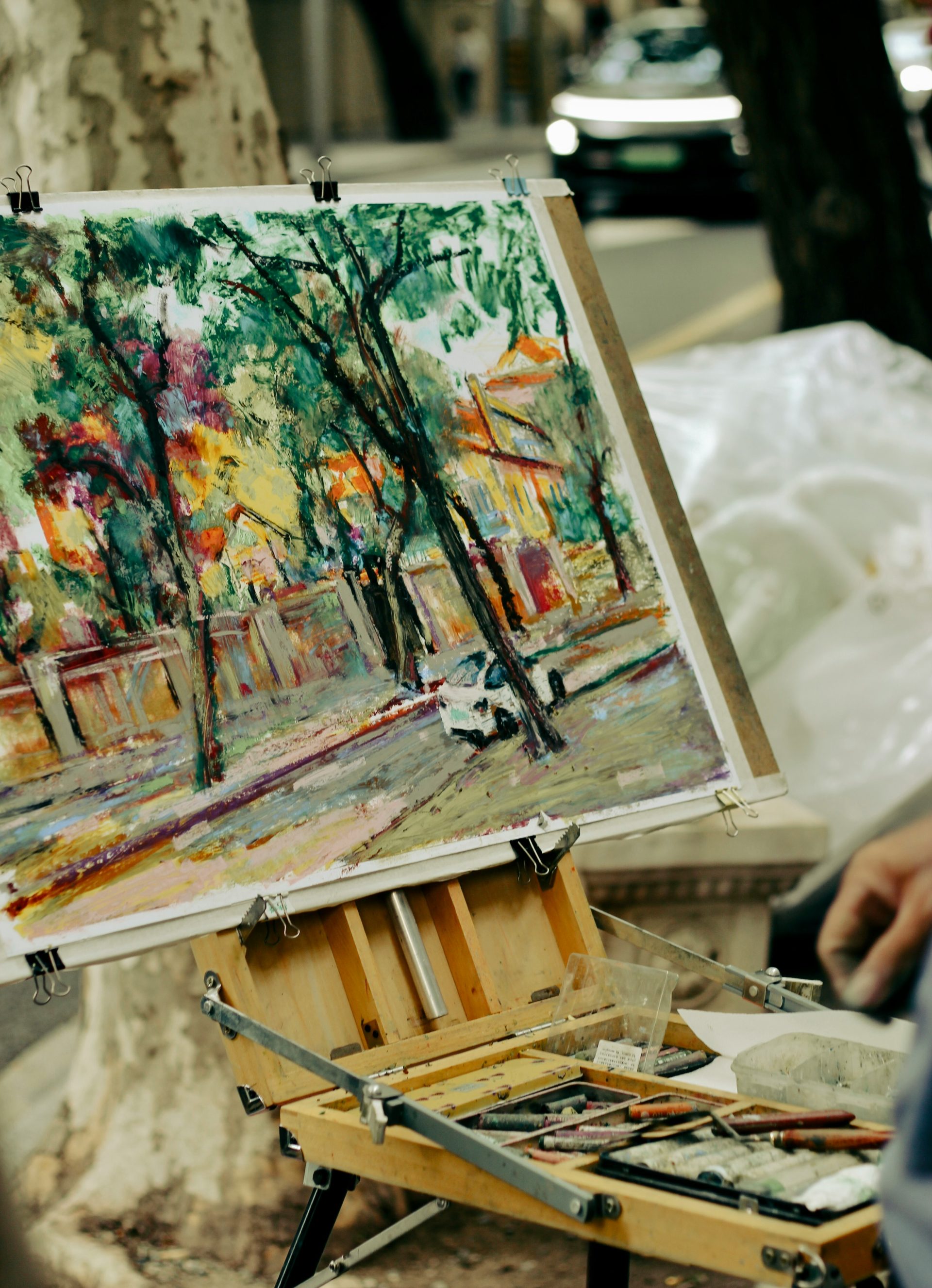 Artist paints a vibrant street scene outdoors